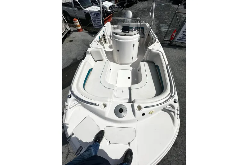 Slide: The Image of 2003 Godfrey Hurricane GS 211 boat interior with seating and console, parked outdoors. - 5