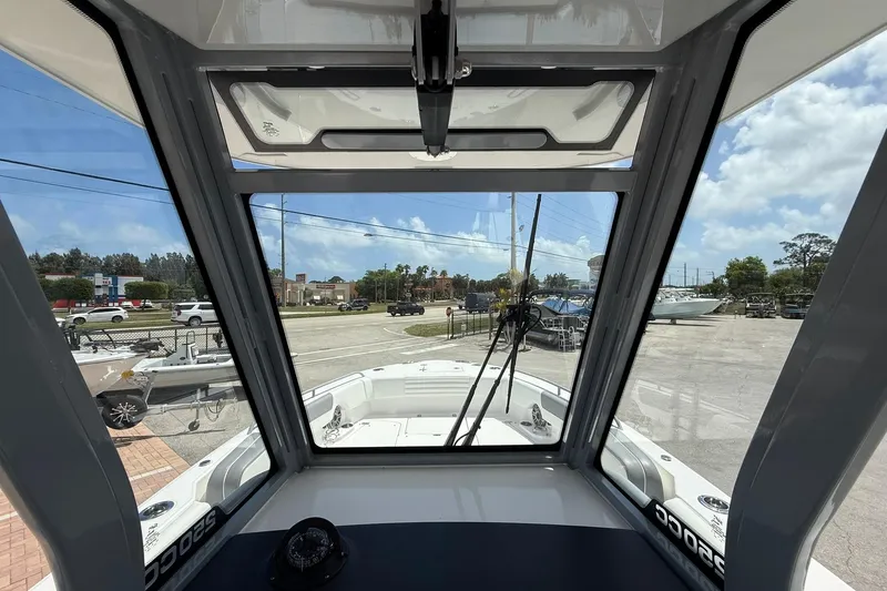 Slide: The Image of Interior view of 2026 Edgewater 250CC boat through windshield, showcasing marina and sky. - 13