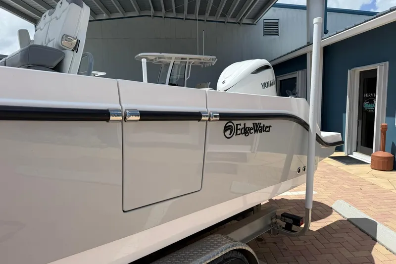 Slide: The Image of 2026 Edgewater 250CC boat with Yamaha engine, parked under a shelter. - 3