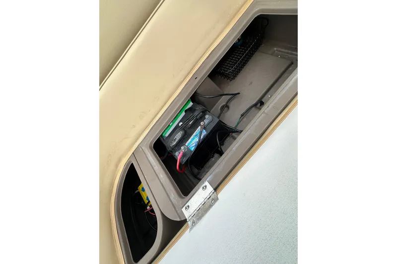 Slide: The Image of Battery compartment of 2018 Princecraft Vectra 23 XT boat, showing wiring and storage. - 18