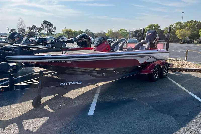 The Image of 2018 Nitro Z21 bass boat parked in a lot, featuring sleek design and dual motors. - 0