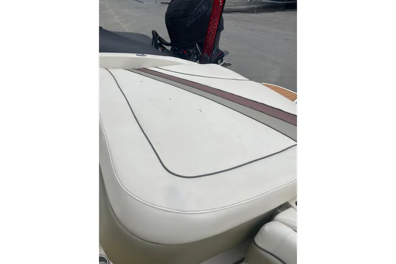 Slide: The Image of 2007 Sea Ray 220 Select boat with white cushioned seating and red accent stripe. - 11