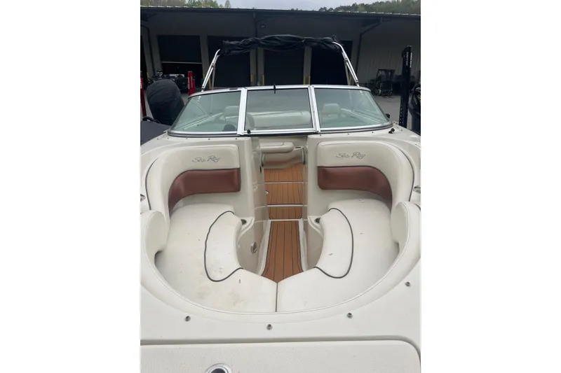 Slide: The Image of 2007 Sea Ray 220 Select boat interior with white and brown seating, docked in a marina. - 6
