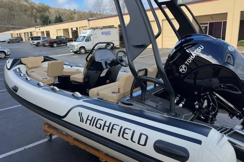 Slide: The Image of 2026 Highfield Sport 520 boat with Tohatsu engine, parked outdoors. - 14