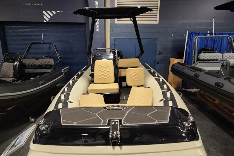 Slide: The Image of 2026 Highfield Sport 520 boat with beige seating, displayed indoors at a showroom. - 6