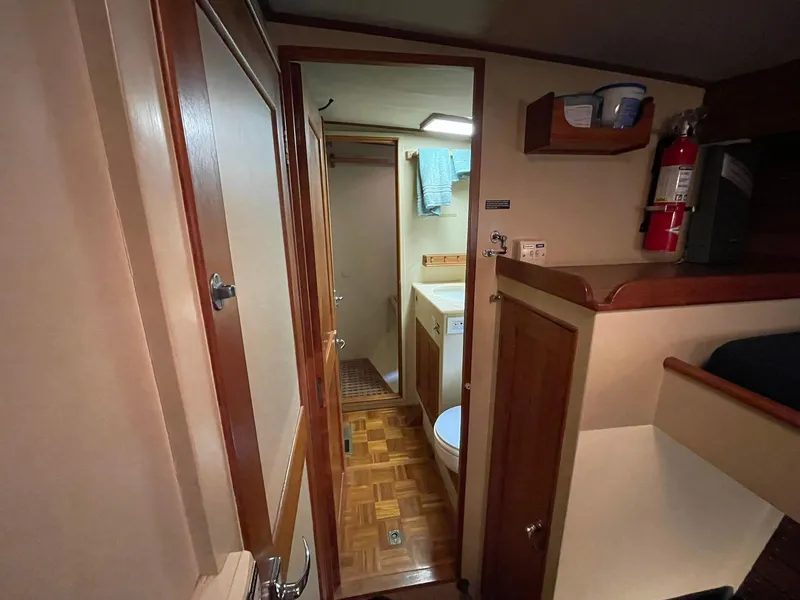 Slide: The Image of Interior of 1972 Grand Banks Alaskan 55 yacht, featuring a compact bathroom and wooden cabinetry. - 14