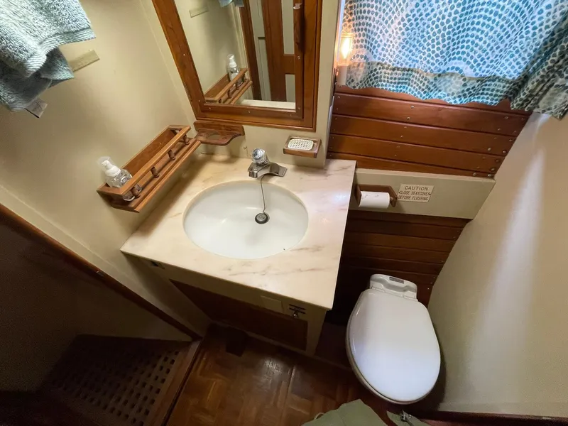 Slide: The Image of 1972 Grand Banks Alaskan 55 yacht bathroom with sink, mirror, and toilet. - 15