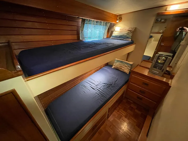 Slide: The Image of Interior of 1972 Grand Banks Alaskan 55 with wooden bunk beds and storage. - 17