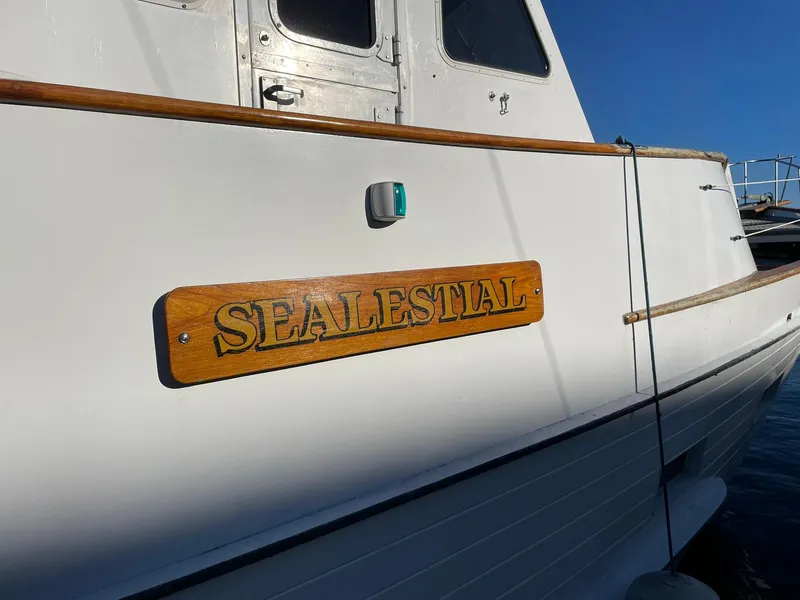 Slide: The Image of 1972 Grand Banks Alaskan 55 boat with "SEALESTIAL" nameplate, white exterior, docked. - 2