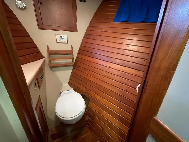 Slide: The Image of 1972 Grand Banks Alaskan 55 yacht bathroom with wooden paneling and compact design. - 31