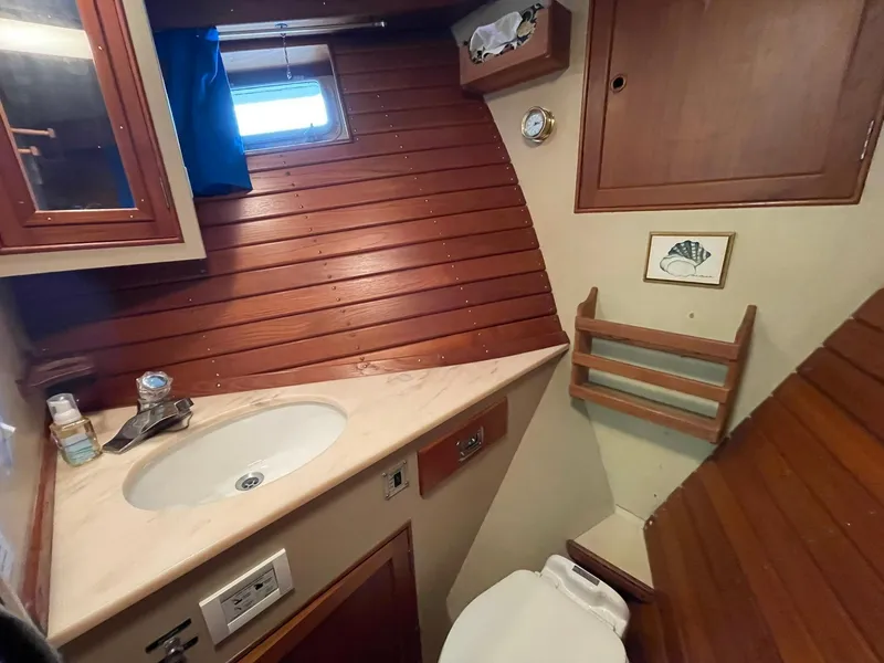 Slide: The Image of 1972 Grand Banks Alaskan 55 yacht bathroom with wooden paneling, sink, and toilet. - 32
