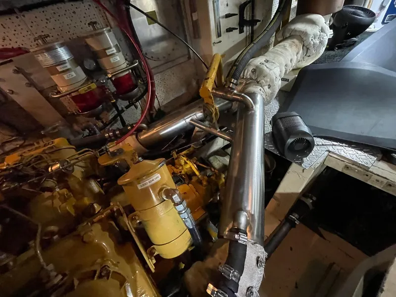 Slide: The Image of Engine room of 1972 Grand Banks Alaskan 55 yacht, showcasing mechanical components and piping. - 44