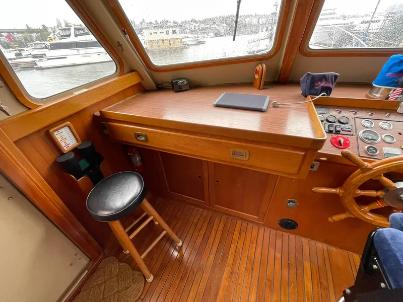 Slide: The Image of 1972 Grand Banks Alaskan 55 helm with wooden desk, stool, and steering wheel. - 5