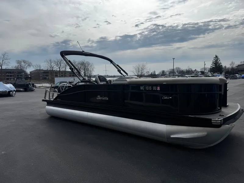 Slide: The Image of 2022 Barletta C22UC pontoon boat parked under cloudy sky. - 1