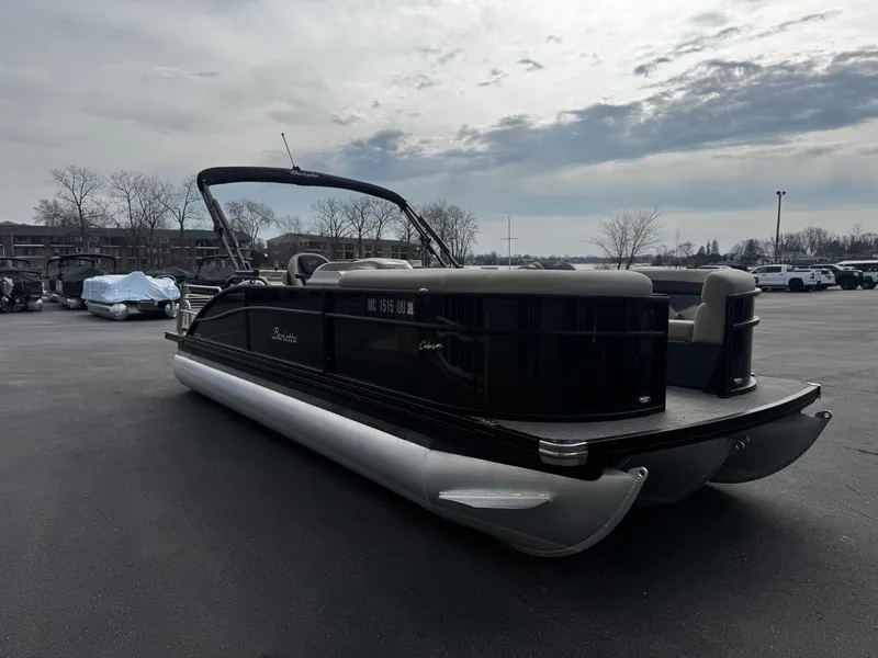 Slide: The Image of 2022 Barletta C22UC pontoon boat on parking lot under cloudy sky. - 2