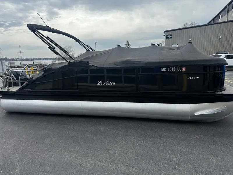 Slide: The Image of 2022 Barletta C22UC pontoon boat with cover on parking lot. - 23