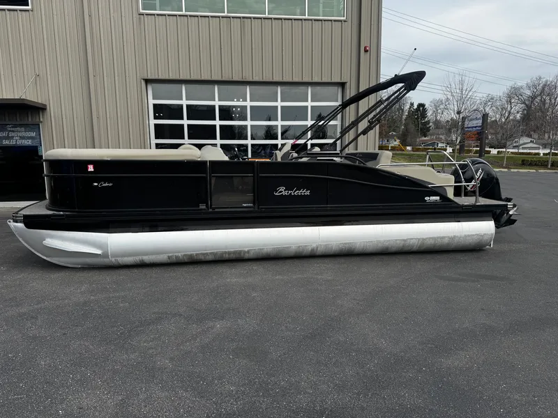 Slide: The Image of 2022 Barletta C22UC pontoon boat parked outside a building. - 5