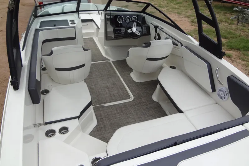 Slide: The Image of 2018 Sea Ray SPX 210 boat interior with white seating and modern dashboard. - 19
