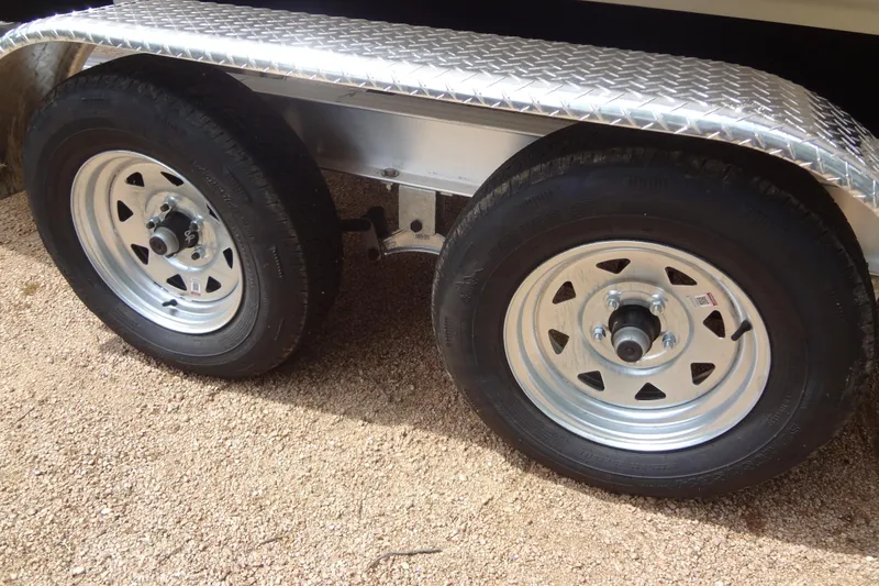 Slide: The Image of Trailer wheels for 2018 Sea Ray SPX 210 boat on gravel surface. - 33