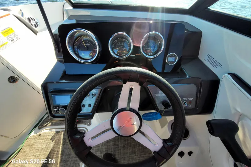 Slide: The Image of Steering wheel and dashboard of a 2018 Sea Ray SPX 210 boat, featuring gauges and controls. - 36
