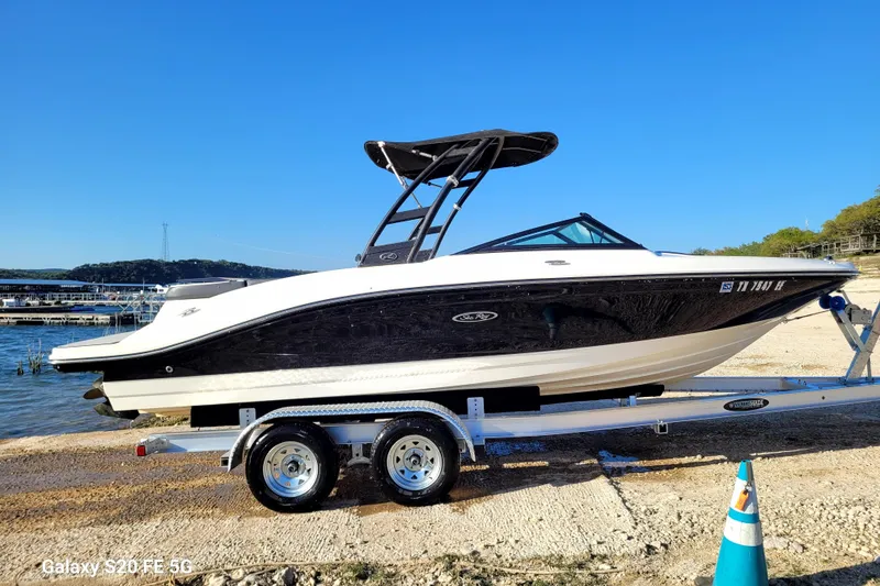 Slide: The Image of 2018 Sea Ray SPX 210 boat on trailer by lakeside under clear blue sky. - 39