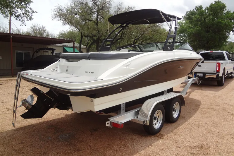 Slide: The Image of 2018 Sea Ray SPX 210 boat on trailer, parked outdoors near trees. - 4
