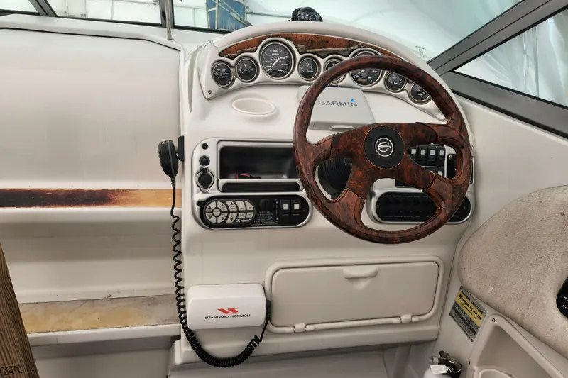 Slide: The Image of 2005 Crownline 275 CCR boat dashboard with woodgrain steering wheel and Garmin navigation system. - 15