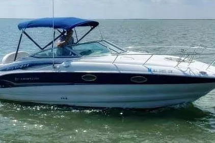 Slide: The Image of 2005 Crownline 275 CCR boat cruising on open water with blue canopy. - 3