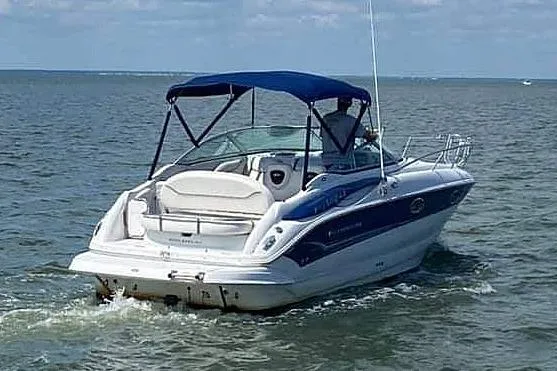 Slide: The Image of 2005 Crownline 275 CCR boat cruising on open water with blue canopy. - 4