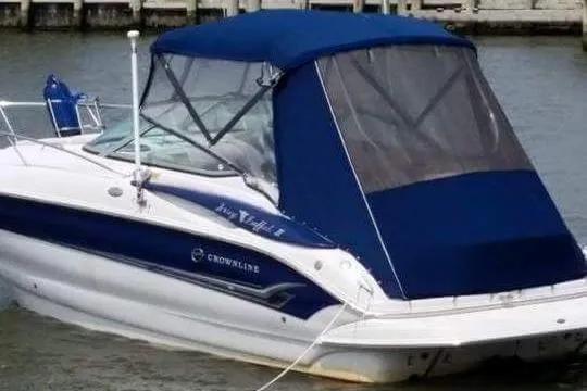 Slide: The Image of 2005 Crownline 275 CCR boat with blue canopy docked in water. - 5