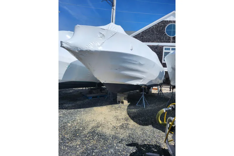 Slide: The Image of 2005 Crownline 275 CCR boat covered in protective wrap, stored outdoors. - 7