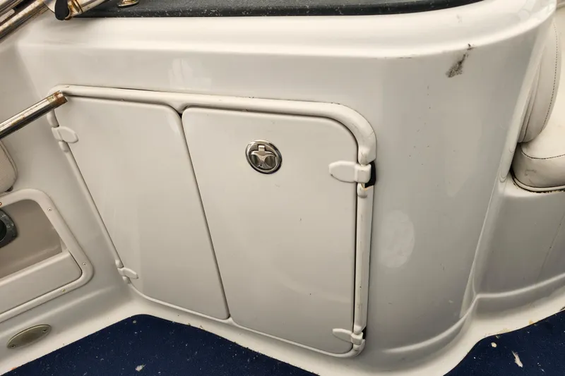 Slide: The Image of 2005 Crownline 275 CCR boat interior with storage compartment and blue carpet. - 8