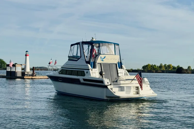 Slide: The Image of 1989 Carver 38 Santego yacht on water near lighthouse, displaying American flag. - 10