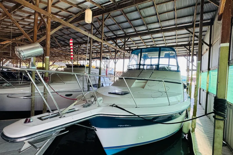 Slide: The Image of 1989 Carver 38 Santego yacht docked in a covered marina. - 11