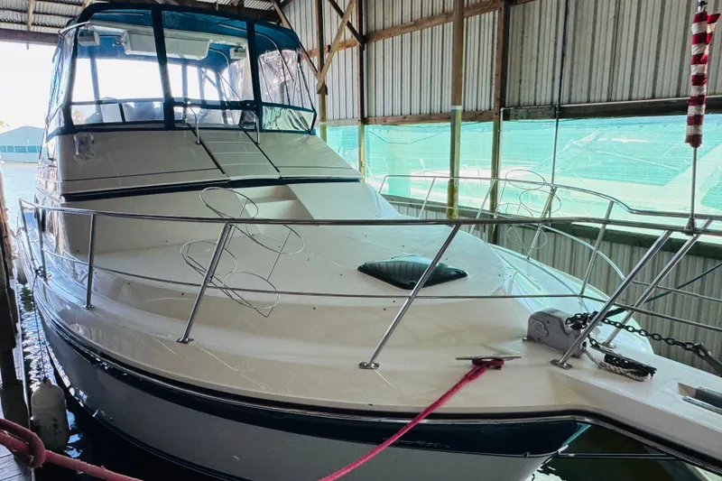 Slide: The Image of 1989 Carver 38 Santego yacht docked in a covered marina. - 12