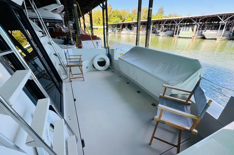 Slide: The Image of 1989 Carver 38 Santego yacht deck with chairs, docked by a serene marina. - 17