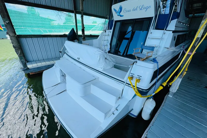 Slide: The Image of 1989 Carver 38 Santego yacht docked, featuring spacious deck and "Casa del Lago" signage. - 18