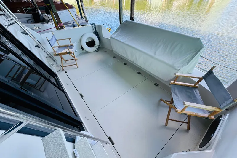 Slide: The Image of 1989 Carver 38 Santego yacht deck with chairs and covered seating area. - 21