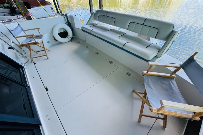 Slide: The Image of 1989 Carver 38 Santego boat deck with seating and chairs by the water. - 22