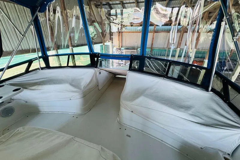 Slide: The Image of 1989 Carver 38 Santego boat interior with white seating and blue canopy. - 27