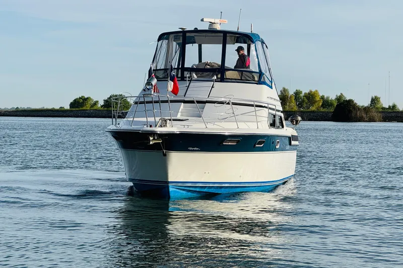 Slide: The Image of 1989 Carver 38 Santego yacht cruising on calm waters, clear sky background. - 3