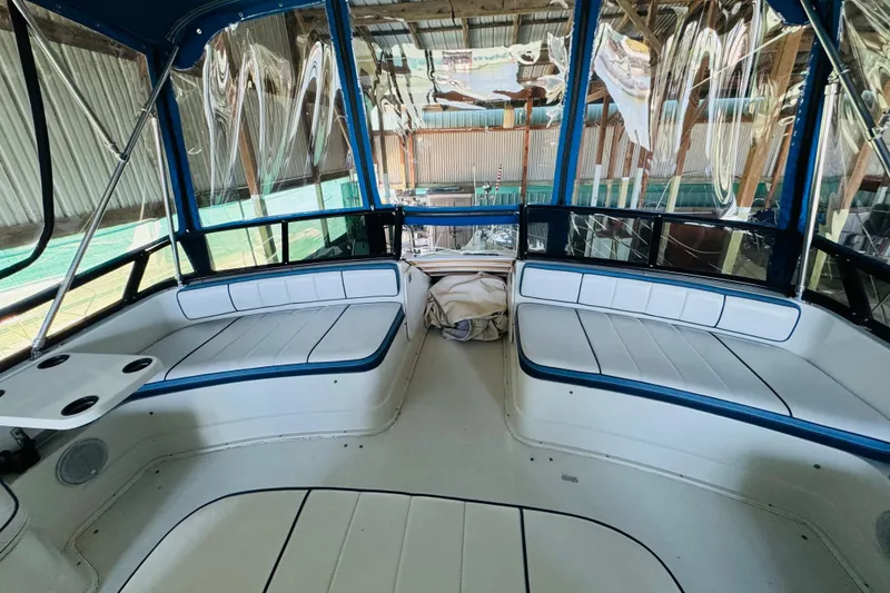 Slide: The Image of 1989 Carver 38 Santego boat interior with blue and white seating in a covered dock. - 31