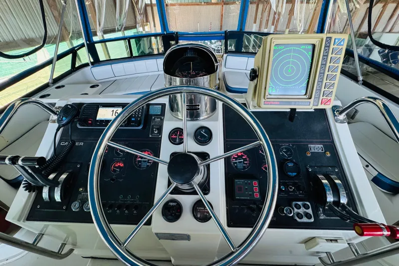 Slide: The Image of 1989 Carver 38 Santego helm with steering wheel, radar, and navigation controls. - 38