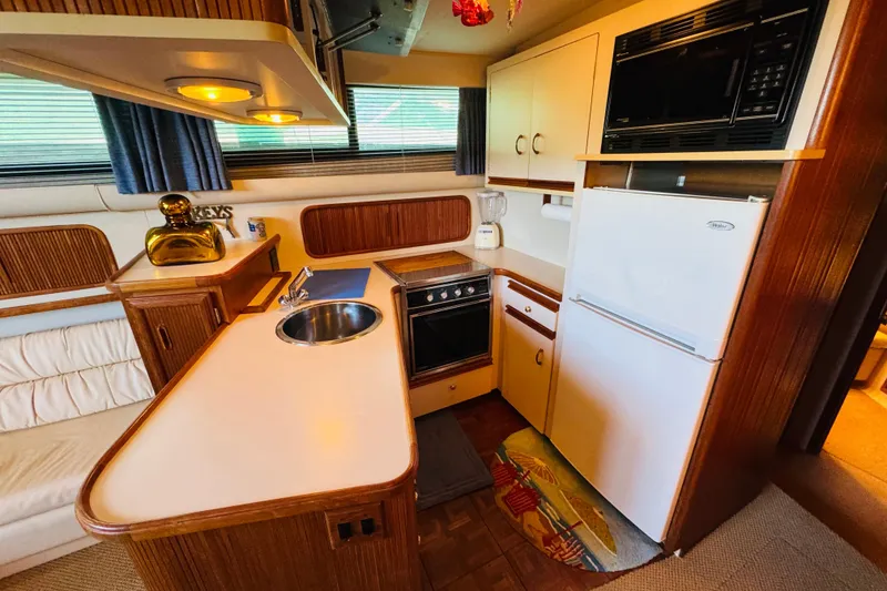 Slide: The Image of 1989 Carver 38 Santego yacht kitchen with sink, stove, fridge, and microwave. - 53