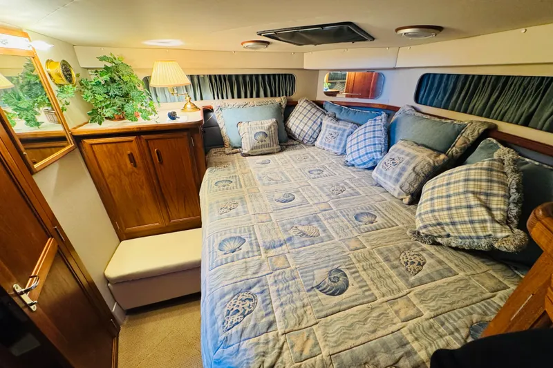 Slide: The Image of Cozy cabin interior of 1989 Carver 38 Santego with nautical-themed bedding and wooden cabinetry. - 59