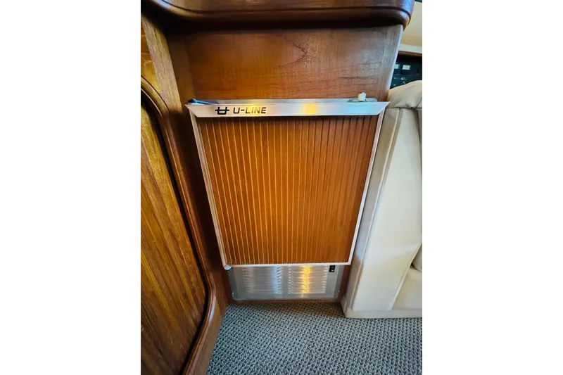 Slide: The Image of 1989 Carver 38 Santego interior with U-Line appliance, featuring wood paneling and beige upholstery. - 66