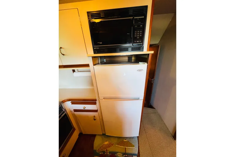 Slide: The Image of Compact kitchen area in a 1989 Carver 38 Santego yacht with microwave and fridge. - 69