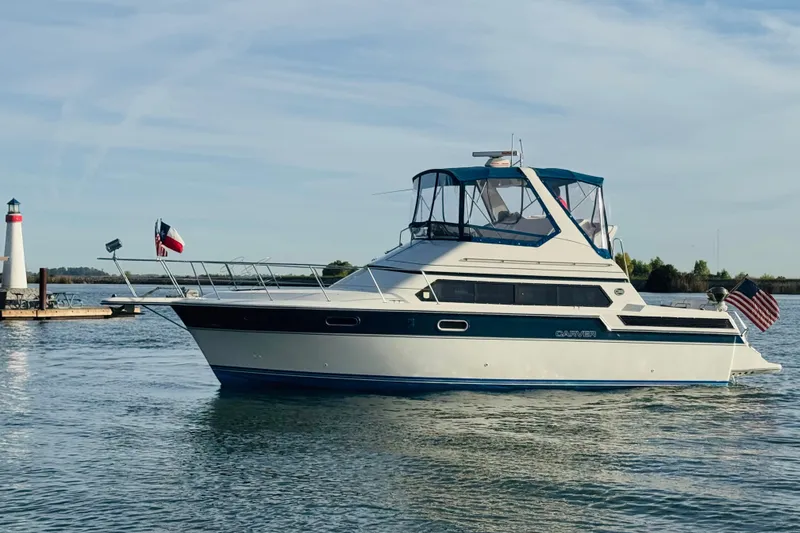 Slide: The Image of 1989 Carver 38 Santego yacht on calm water near a lighthouse. - 7