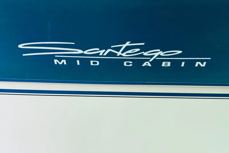 Slide: The Image of 1989 Carver 38 Santego Mid Cabin boat logo on blue background. - 78