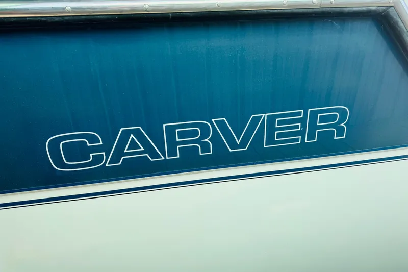 Slide: The Image of Carver 38 Santego 1989 boat logo on blue background. - 79